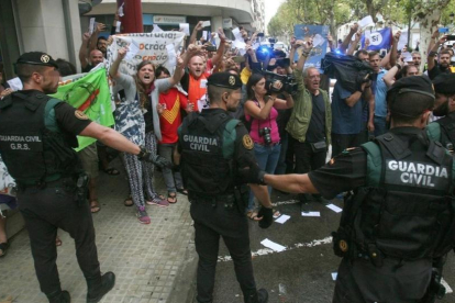 Guardias civiles ante un grupo de manifestantes, durante el registro del semanario El Vallenc