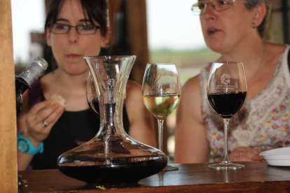 Dos mujeres disfrutan de los vinos Tierra de León en la última feria de la asociación.