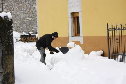 Un vecino espala la nieve en Lillo. CAMPOS