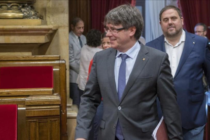 El presidente de la Generalitat, Carles Puigdemont, y el vicepresidente del Govern, Oriol Junqueras, en el hemiciclo del Parlament.
