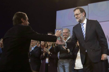 El presidente del Gobierno, Mariano Rajoy, saluda a José María Aznar al finalizar el acto de clausura de la convención nacional del PP.