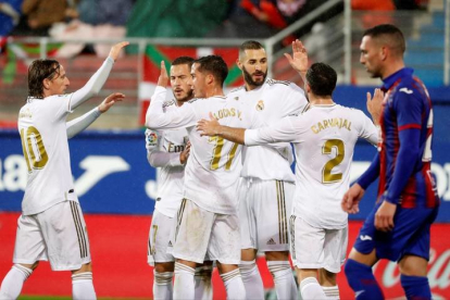 Los jugadores del Real Madrid celebran el segundo gol de Karim Benzema en el partido ante el Eibar, correspondiente a la décimo tercera jornada de LaLiga Santander, disputada este sábado en el estadio Municipal de Ipurúa. EFE/Juan Herrero.