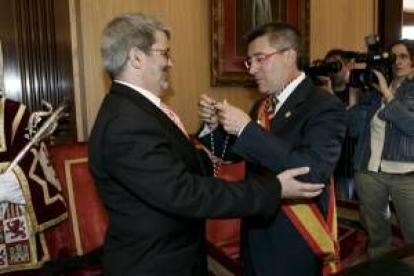 Agustín Mariano Pérez Lamo, el número 13, sonríe mientras el alcalde le coloca la medalla de edil