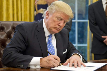 Donald Trump firma un documento en su despacho de la Casa Blanca. RON SACHS