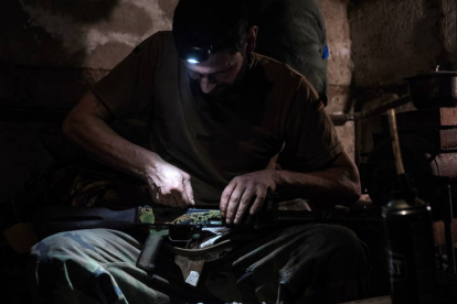 Un soldado ucraniano limpia su arma. EFE