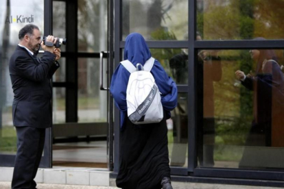 Un miembro de la escuela musulmana de secundaria Al Kindi filma a una estudiante mientras entra en el centro educativo en Decines, cerca de Lyon (Francia).