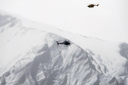 Dos helicópteros patrullan sobre los Alpes franceses durante un rescate.