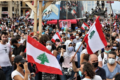Manifestantes ondean banderas del Líbano en una manifestación de protestas tras la explosión del puerto de Beirut. NABIL MOUNZER