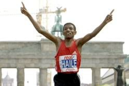 Gebrselassie levanta los brazos tras cruzar la meta en la capital alemana