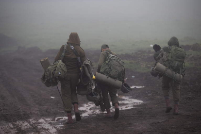 Soldados israelíes se desplazan ayer entre la niebla en los Altos del Golán. ATEF SAFADI