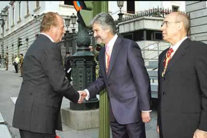 Después del desfile militar, el Rey Juan Carlos es recibido por el presidente del Congreso, Manuel Marín, y el pesidente del Senado, Javier Rojo, a las puertas del Congreso de los Diputados.