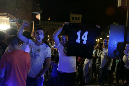 Un fan muestra una camiseta con el número 14 por el número de Champions logradas por el Madrid. FERNANDO OTERO
