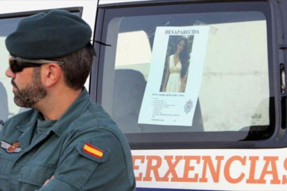 Un agente de la Guardia Civil, el 1 de septiembre, junto al cartel de búsqueda de Diana Quer, desaparecida en A Pobra do Caramiñal (A Coruña).