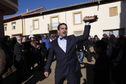 Distintas imágenes de la subasta de tartas en honor a San Antón a las puertas de la iglesia de Algadefe y fotografía de la escultura y fuente dedicada a la natalidad, ubicada en una de las plazas más céntricas del pueblo.