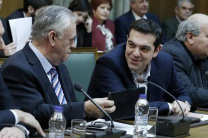 Tsipras (segundo por la derecha) habla con el viceprimer ministro, Yannis Dragasakis, en la primera reunión del Consejo de Ministros, este miércoles en Atenas.