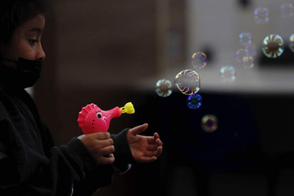 Una niña juega con una pistola de burbujas. ESTEBAN BIBA