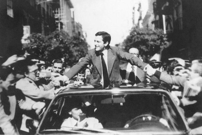 Adolfo Suárez saluda desde su coche durante una campaña