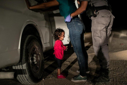 Yana, de Honduras, llora mientras su madre, Sanda Sánchez, es registrada por un agente fronterizo en McAllen, Texas, Estados Unidos. / JOHN MOORE (GETTY IMAGES)