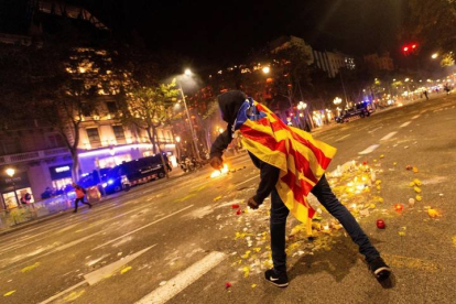 Un manifestante se enfrenta a los Mossos de Escuadra junto a la Delegación del Gobierno en Barcelona. ENRIC FONTCUBERTA