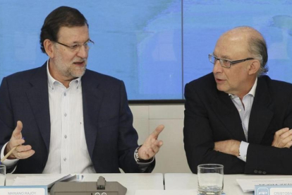 El presidente del Gobierno, Mariano Rajoy, y el ministro de Hacienda, Cristóbal Montoro, en la sede del PP en junio del 2014