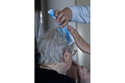 Una anciana recibe ayuda en su domicilio. EFE