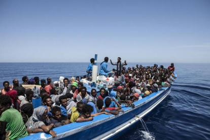 Inmigrantes a bordo de una patera intentando cruzar el Mediterráneo son rescatados por la Marina Militar italiana.