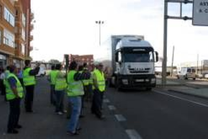 Un grupo de camioneros invita a detenerse a un camión que cruza la travesía de la N-VI en La Bañeza