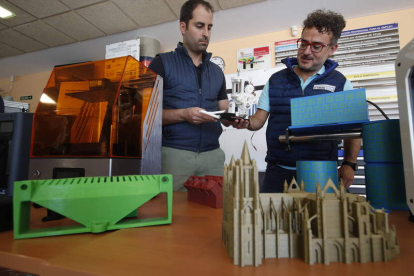 Jesús Fernández, de León 3D, y Enrique Blanco, director del CIFP Tecnológico Industrial de León, con algunas de las imrpesoras. RAMIRO