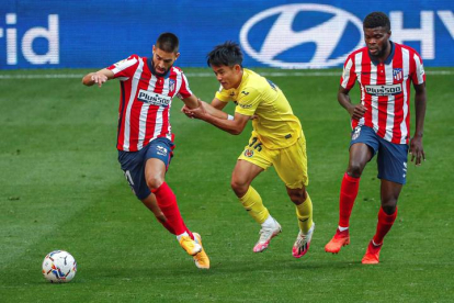 El centrocampista japonés del Villarreal Takefosa Kubo (c) pelea un balón con el centrocampista belga del Atlético de Madrid Yannick Ferreira Carrasco (i). EMILIO NARANJO