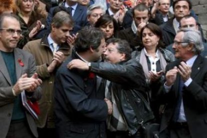 El alcalde de Barcelona y el director de Barcelona Solidaria se abrazan en la concentración.