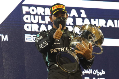 El piloto británico Lewis Hamilton celebra en el podio el triunfo en el Gran Premio de Baréin. XHEMAJ