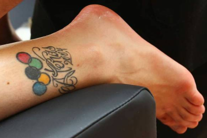Carolina luce un tatuaje con los aros olímpicos y el lema ‘atenas 2004’ en el tobillo dañado. Foto: Norberto.