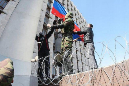 Manifestantes prorrusos izan la bandera de la autodenominada República de Donetsk, en la sede del Gobierno local, este lunes.