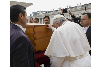 Francisco posa sus manos sobre el féretro de Benedicto XVI. VATICAN MEDIA