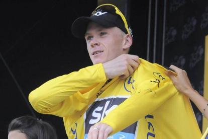 El ciclista británico Christopher Froome, del Sky, se enfunda en el podium el maillot amarillo de líder tras disputar la 18ª etapa del Tour de Francia, entre las localidades de Gap y L'Alpe d'Huez, en Francia, hoy, jueves 18 de julio de 2013.