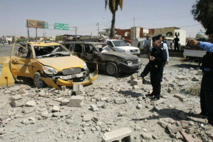 Policías iraquís observan el atentado perpetrado en Kirkuk, uno de los 16 que ataques perpetrados hoy en Irak.