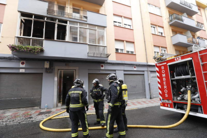 Los bomberos, junto a la vivienda que ardió. MARCIANO PÉREZ