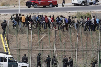 Imagen de esta mañana con el grupo de inmigrantes encaramado a la valla fronteriza.