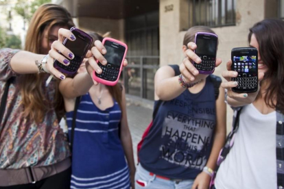 Tres adolescentes muestran sus teléfonos, en una imagen del 2011.