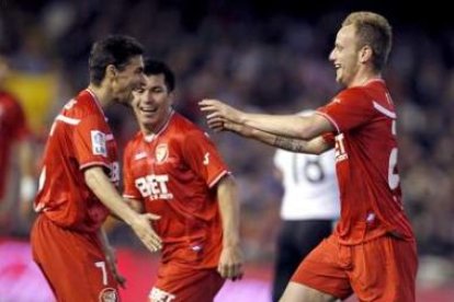 Rakitic (d) celebra su gol con sus compañeros Jesús Navas (i) y el chileno Gary Medel.
