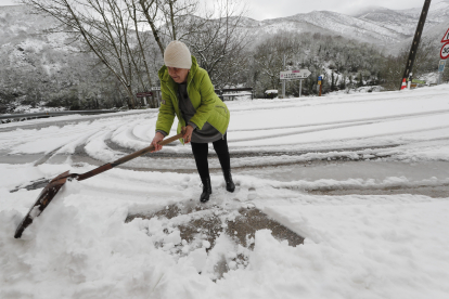 Una vecina retira la nieve de la calle en Vega de Valcarce. L. DE LA MATA