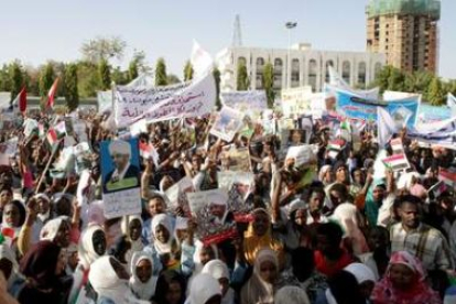Sudaneses sostienen pósters del presidente sudanés Omar Al-Bashir en una manifestación en Jartúm