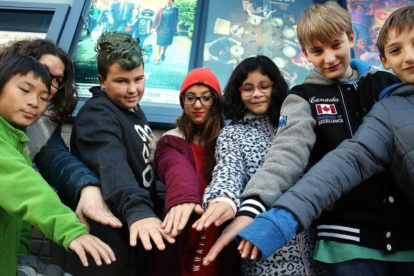 Un grupo de niños, algunos de ellos con fisura labial, juntan sus manos antes de entrar en el cine para ver la película Wonder, el domingo pasado en Cerdanyola.