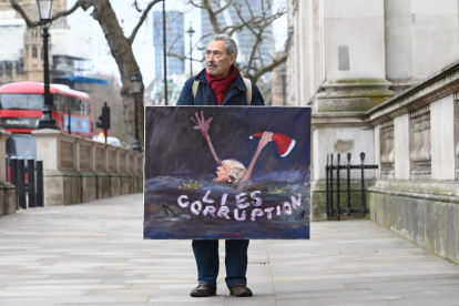 Imagen de un hombre con un cartel satírico. JAVIER AGUIRREZABALAGA