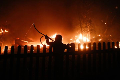 Un ciudadano trata de apagar las llamas en el área de Varybobi (Atenas). EFE/EPA/YIANNIS KOLESIDIS
