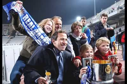 El entrenador del Real Zaragoza Victor Muñoz y el segundo entrenador, Raul Longhi, posan con el trofeo, acompañados de sus hijos.