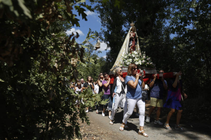 La procesión discurre entre los árboles que crecen a orillas del río Torío.. FERNANDO OTERO