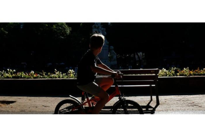 Un niño pasea en bicicleta por un parque de León. FERNANDO OTERO