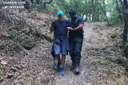 Un agente de la Guardia Civil ayuda al senderista en Noceda. DL