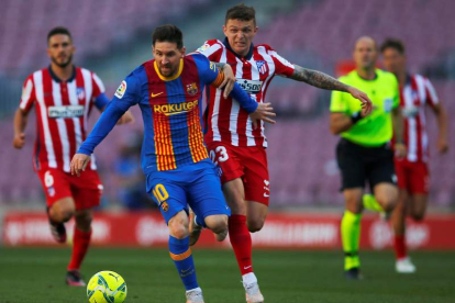 Leo Messi pugna con Kieran Trippier durante un lance del partido de Liga disputado en el Camp Nou. ENRIC FONTCUBERTA